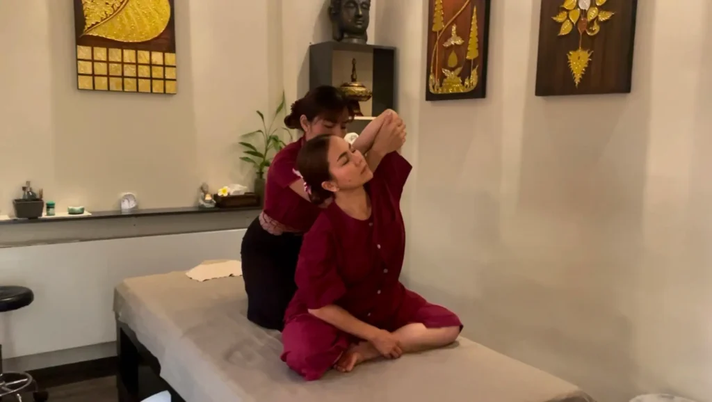 Streckposition der traditionellen Thai Massage zur Dehnung der Schulter.