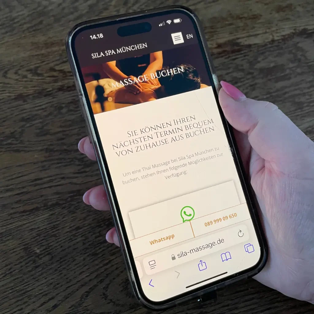 Frau öffnet die Buchungsseite von Sila Spa München auf ihrem Handy
